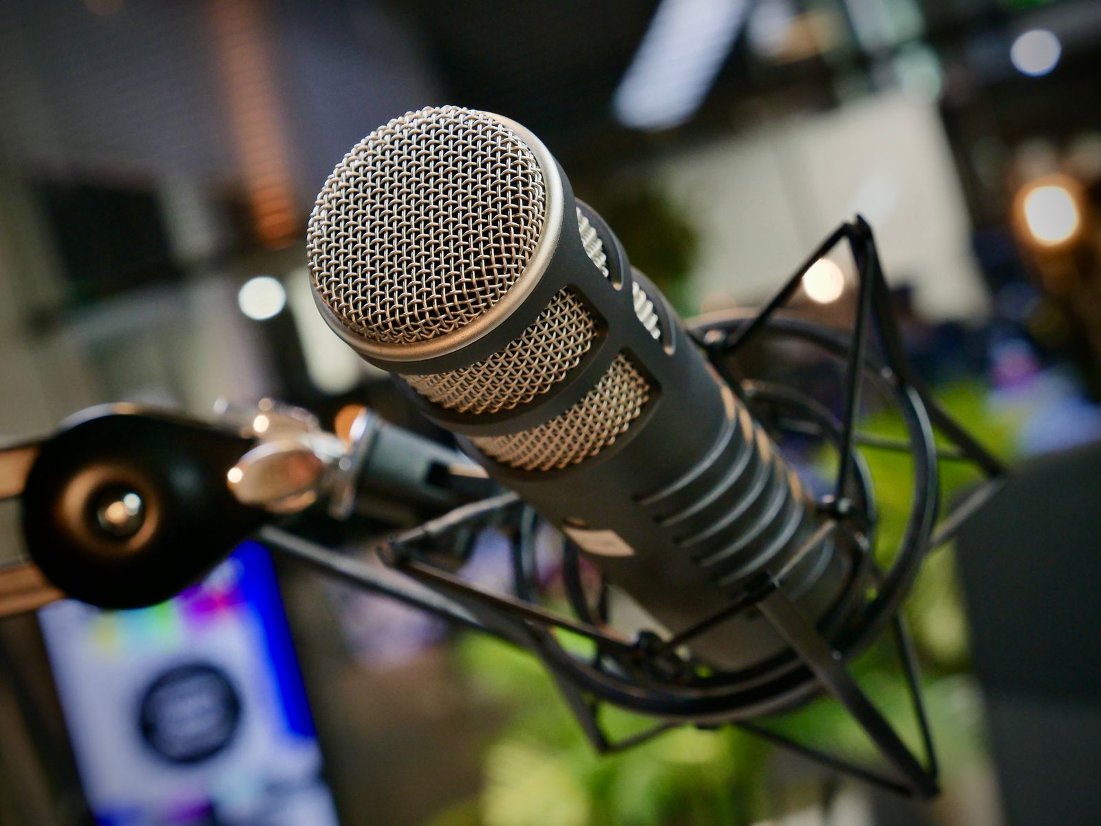 A broadcast microphone in a warmly lit studio